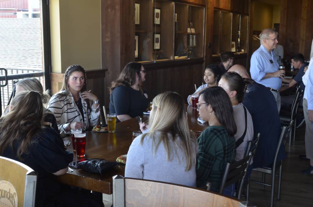 Seidman Alumni sitting around a table at Founders Brewing